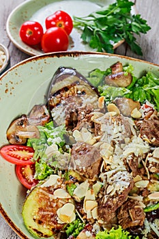 Hot salad with veal, mushrooms, salad leaves, eggplant, zucchini, tomatoes,