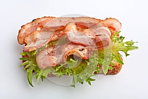 Hot sandwich with fried bacon and lettuce