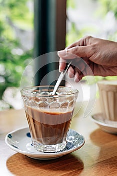 Hot served Vietnamese coffee that can wake you up: Black coffee mix with condense milk in clear glass served on wooden table