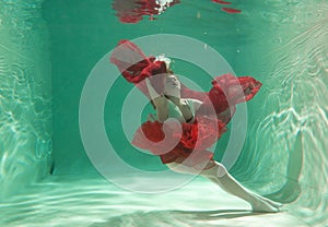 Hot Slim Woman Posing Under water in beautiful clothes alone in the deep