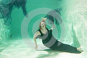 Hot Slim Woman Posing Under water in beautiful clothes alone in the deep