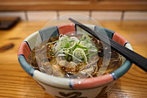 Hot soba with stir fried mushroom in Japanese bowl on timber table