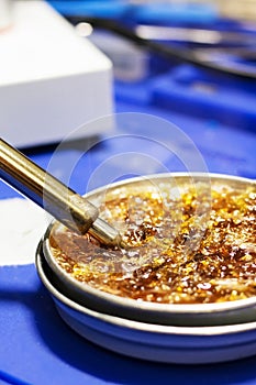 Hot soldering iron and yellow rosin closeup