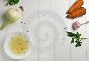 Fresh bouillon in a white plate with finely chopped herbs with ingredients on a white background. photo