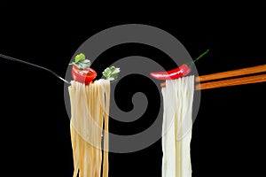 Hot spagetti on the fork with tomato and parsley and Asian noodles on chopsticks with red pepper.