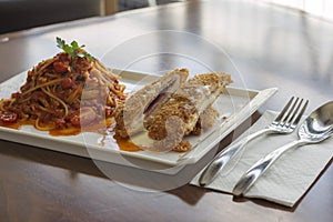 Hot Spaghetti Pomodoro chicken parmigiana on a table