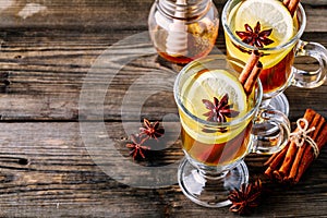 Hot spiced Apple cider Toddy with lemon, honey and cinnamon stick in glass