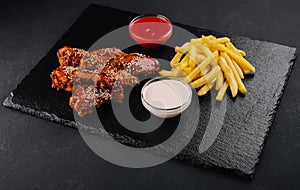 Hot and spicy buffalo chicken wings and french fries