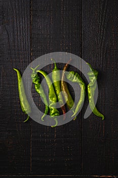 Hot spicy green chili peppers on dark wooden backdrop background