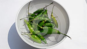 Hot spicy green chilies or cabe rawit hijau on bowl  on white background