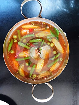 Hot and spicy soup in a pot on the table, Thailand.