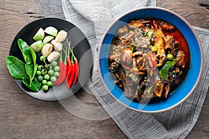 Hot and spicy stir - fried ell in bowl on old rustic wooden table.