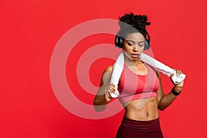 Hot sporty girl with towel and headset over red background