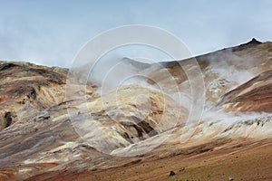 Hot steam raising above colored hills at Hverarond area, Iceland