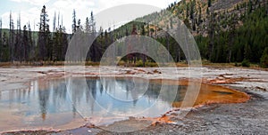 Hot steam rising off Emerald Pool hot spring in the Black Sand Geyser Basin in Yellowstone National Park in Wyoming USA