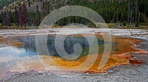 Hot steam rising off Emerald Pool hot spring in the Black Sand Geyser Basin in Yellowstone National Park in Wyoming USA