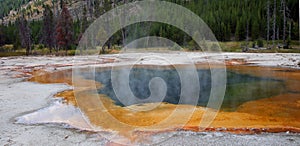 Hot steam rising off Emerald Pool hot spring in the Black Sand Geyser Basin in Yellowstone National Park in Wyoming USA