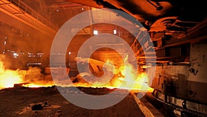 Hot steel being poured to the chute at the steel plant, heavy industry concept. Stock footage. Molten steel production