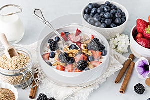 Hot steel cut oatmeal topped with berries and walnuts ready for eating.