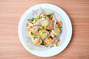 The hot stir fried tofu and pork and mushroom with black bean sauce serve on white dish set on brown table - homemade food concept