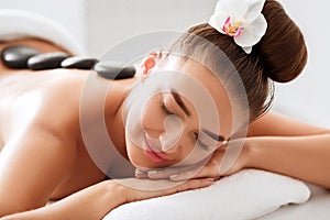 Hot stone massage. Girl relaxing in spa salon