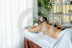Hot stone massage at spa salon in luxury resort. Quiescent photo