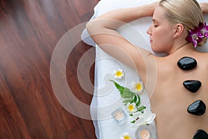Hot stone massage at spa salon in luxury resort. Quiescent photo