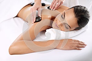 Hot stone, woman and hands massage shoulder for skincare, beauty and pamper body for wellness at luxury salon. Back