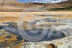 Hot sulfurous gases emerging from boiling mud pool in Iceland