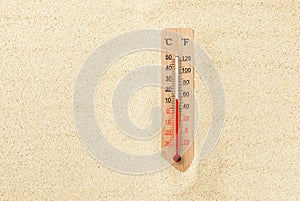 Hot summer day. Celsius and fahrenheit scale thermometer in the sand. Ambient temperature plus 13
