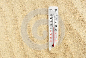 Hot summer day. Celsius and fahrenheit scale thermometer in the sand. Ambient temperature plus 14