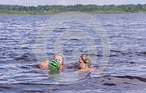 On a hot summer day, children relax on the lake. Girls on the beach. People frolic in the water.