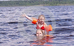 On a hot summer day, children relax on the lake. Girls on the beach. People frolic in the water.