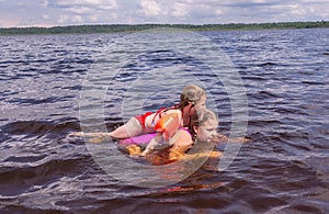 On a hot summer day, children relax on the lake. Girls on the beach. People frolic in the water.