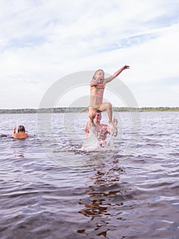 On a hot summer day, children relax on the lake. Girls on the beach. People frolic in the water.