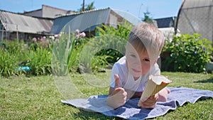 Malý chlapec ležiace na trávnik šťastný na jesť krém. horúci leto studený sladký dezert 