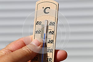 Hot Summer - Thermometer in hand, shows the heat