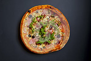 Hot tasty delicious rustic homemade american pizza over black background. Traditional Italian cuisine concept