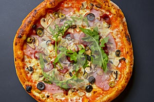 Hot tasty delicious rustic homemade american pizza over black background. Traditional Italian cuisine concept