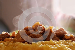 Hot tasty Pilaf (meat of a ram paella) in plate and green lettuce in table