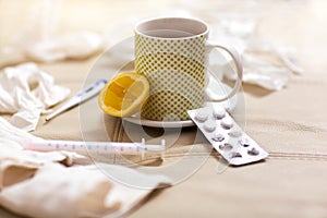 Hot tea for colds, pills handkerchiefs and thermometer