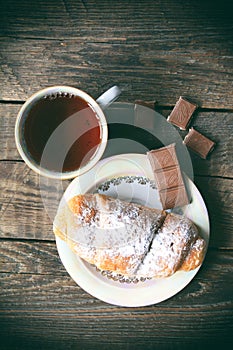 Hot tea with croissant and chocolate. Retro style image