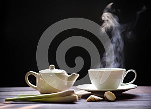 Hot tea cup and teapot on wood background. Hot drink .