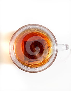 Hot tea in a glass teacup on a white table