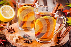 Hot tea with lemon, anise and cinnamon in glass mugs