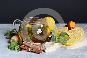 Hot tea with lemon, ginger, honey and mint on a dark background with copy pace. Homemade anti flu drink. Healthy eating concept.