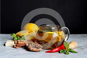 Hot tea with lemon, ginger, honey and mint on a dark background with copy pace. Homemade anti flu drink. Healthy eating concept.