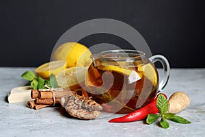 Hot tea with lemon, ginger, honey and mint on a dark background with copy pace. Homemade anti flu drink. Healthy eating concept.