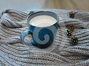 Hot tea with milk, brown knitted scarf and cones