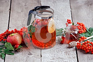 Hot tea from rosehip berries and fruit in transparent glasses and honey on a wooden table. Harvesting, autumn fall winter hot